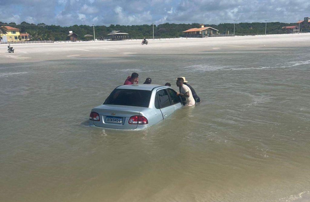 Carro é parcialmente ‘engolido’ pela maré alta na Praia do Farol Velho, em Salinas